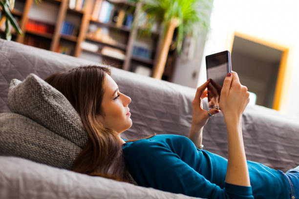 istock Young  woman relaxing with digital tablet at home 516987752