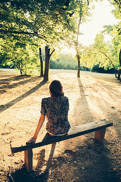 istock Girl sitting on a park bench 516989246