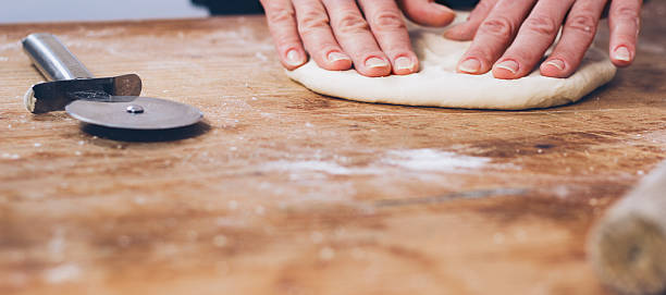 istock Woman hands kneading dough on the table 517005274
