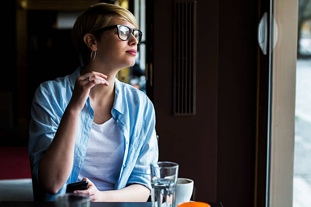 istock Young woman in a cafe looking out the window 517013126