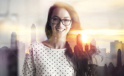 Multiple exposure portrait of a young woman superimposed over a city