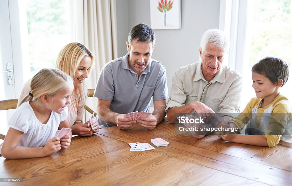 Family fun Shot of a happy three-generational family playing cards together Playing Card Stock Photo