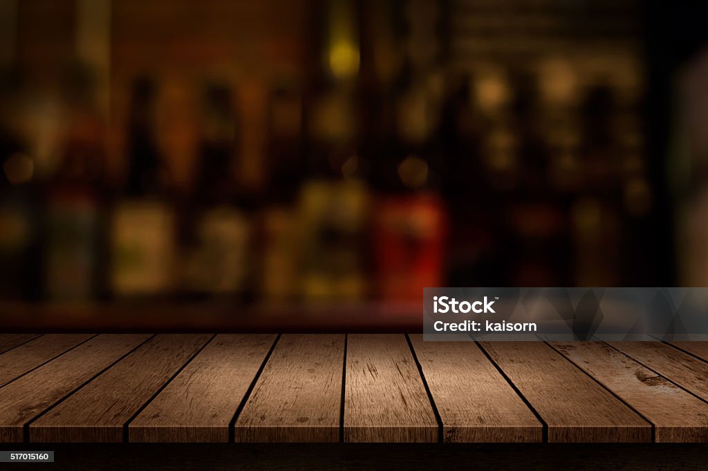 wooden table with a view of blurred beverages bar backdrop Bar Counter Stock Photo