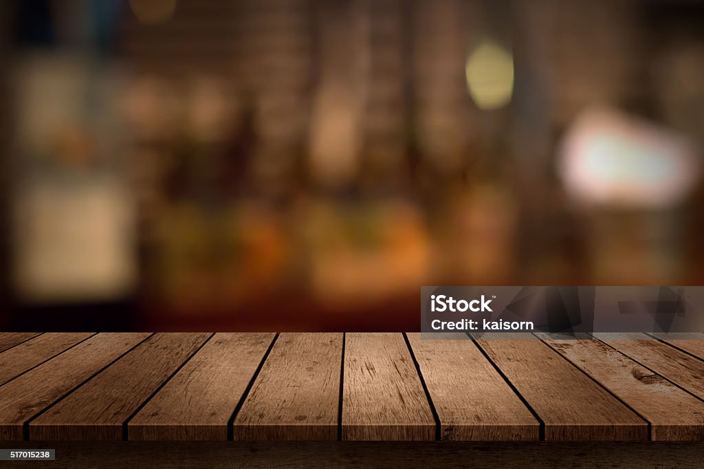 wooden table with a view of blurred beverages bar backdrop Wood - Material Stock Photo