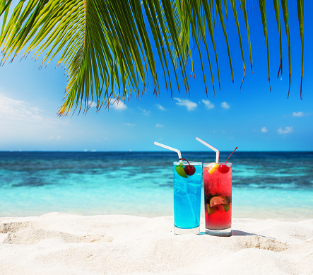 Two fruity cocktails at tropical sunny beach -- In vacation on the tropical beach