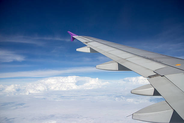 istock Wing of an airplane flying above the clouds 517016637