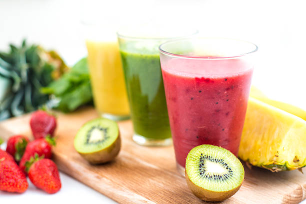 Fresh, healthy smoothies Three fresh, colorful smoothies with some fruit on kitchen table. juice bar stock pictures, royalty-free photos & images