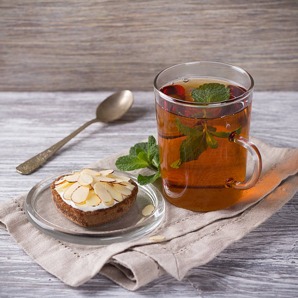 istock Mint tea and cake with cream and almond petals 517019152