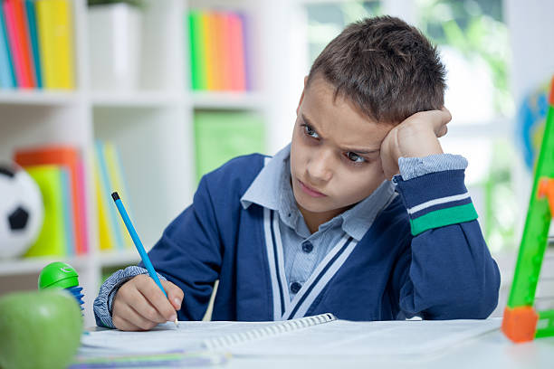 istock Angry and tired schoolboy studying 517019453