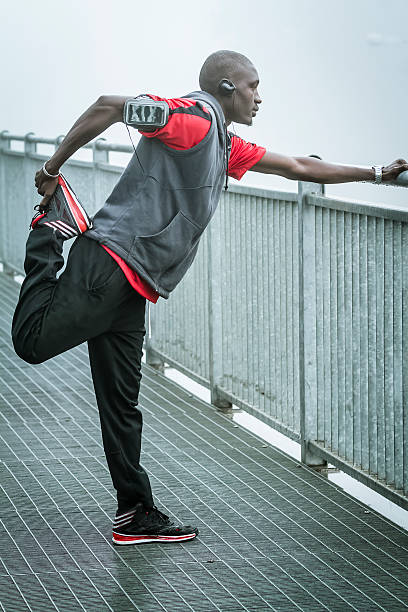istock Young man doing stretching in the fog on Iron Bridge 517042215