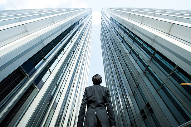 istock Businessman looking up at the high building, low angle 517044166