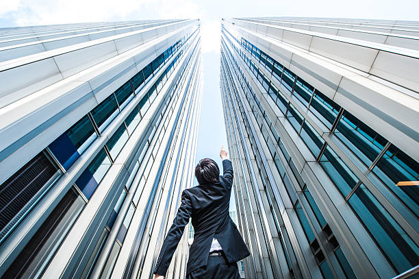 istock Businessman looking up at the high building, low angle 517044200