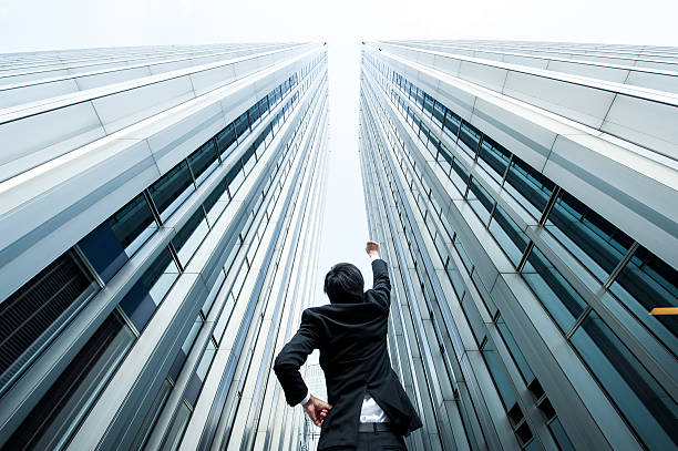 istock Businessman looking up at the high building, low angle 517044236