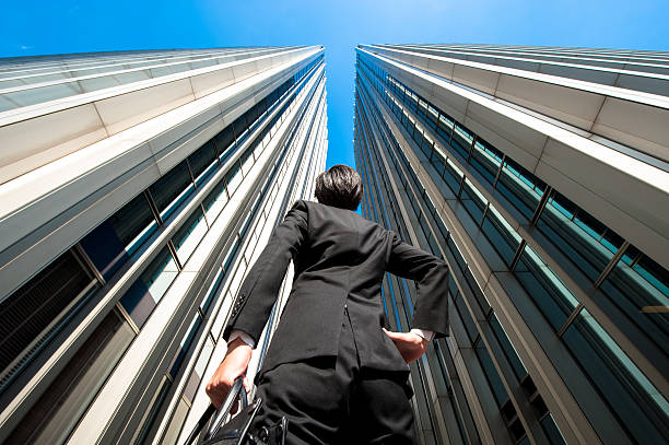 istock Businessman looking up at the high building, low angle 517044260