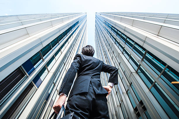 istock Businessman looking up at the high building, low angle 517044286