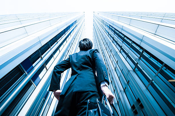 businessman looking up at the high building, low angle - challenge stockfoto's en -beelden