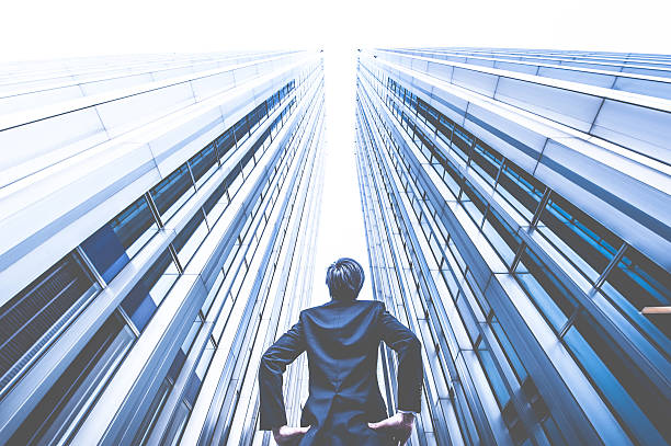 istock Businessman looking up at the high building, low angle 517044344