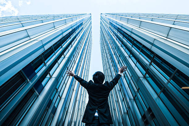 istock Businessman looking up at the high building, low angle 517044408