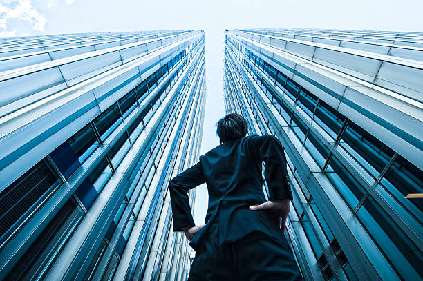 istock Businessman looking up at the high building, low angle 517044460