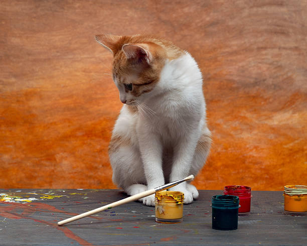 istock On a wooden table paints, brushes and a cute kitten 517044474