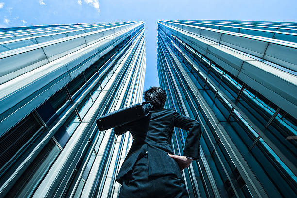 istock Businessman looking up at the high building, low angle 517044488