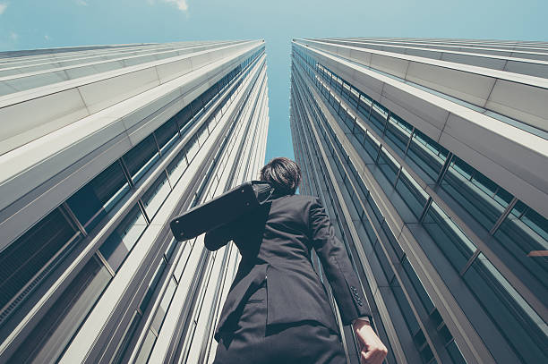 istock Businessman looking up at the high building, low angle 517044534