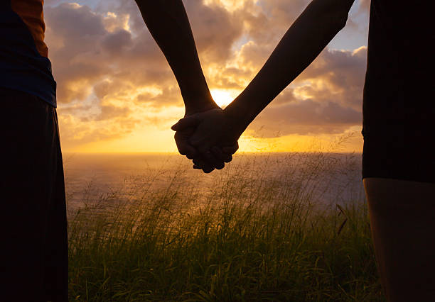 Honeymoon couple Loving couple enjoying beautiful sunset in Hawaii couple holding hands stock pictures, royalty-free photos & images