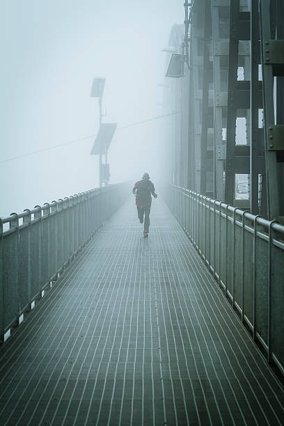 istock Young man Running in the fog on Iron Bridge 517046797