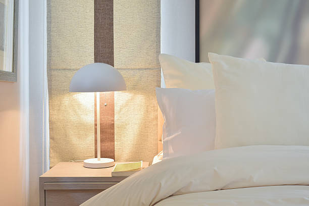 istock Cozy bedroom with pillows and reading lamp on bedside table 517047490