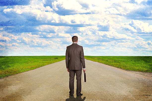 istock Businessman with briefcase standing on the road. Rear view 517047911