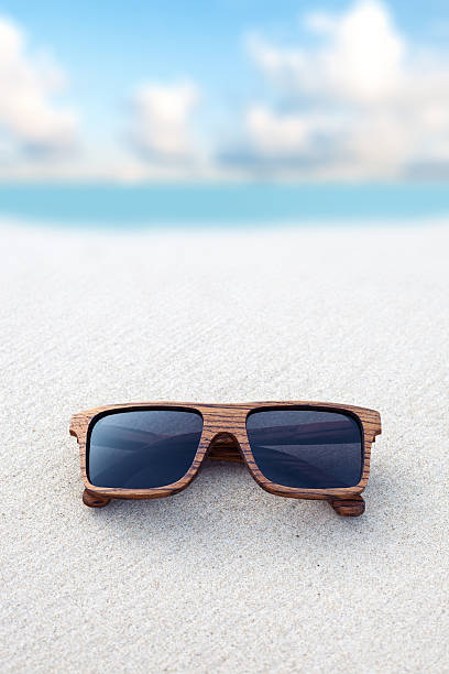 istock wooden sunglasses lying on the beach 517047923
