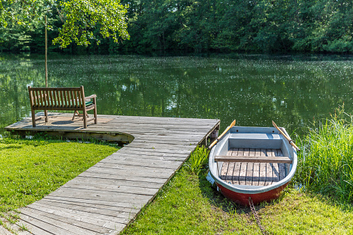 Idyllic scene with bench and row boat  at the Schaalsee in North Germany. 