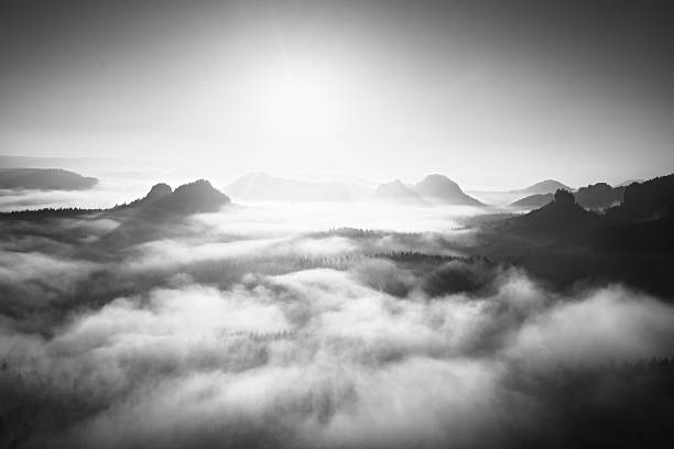 istock Sunrise on rocky mountain, view into deep misty valley. 517048370