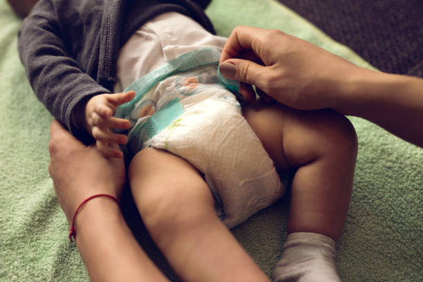 primer plano de la madre de bebé de cambiar los pañales. - 2 5 meses fotografías e imágenes de stock