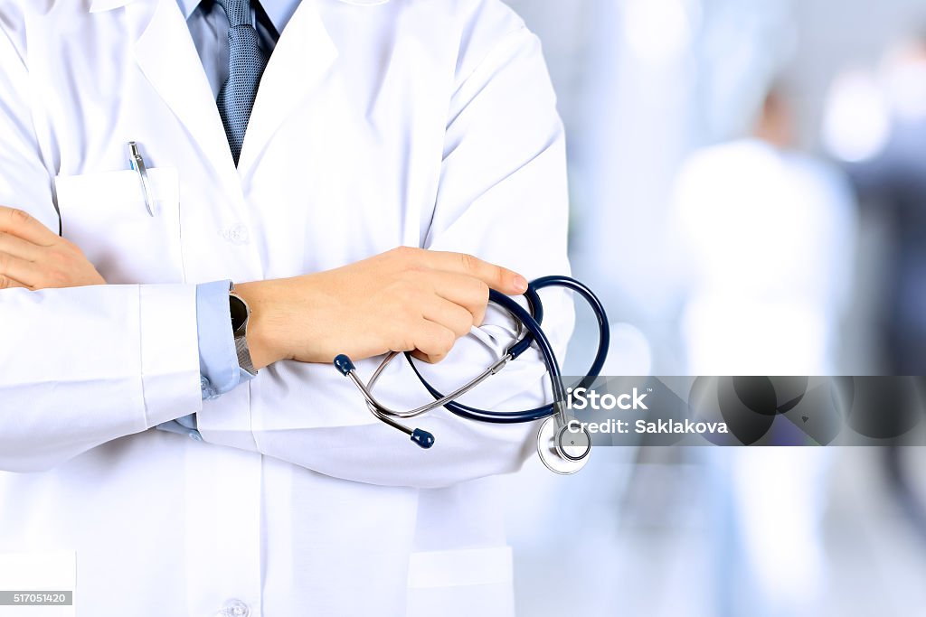 Portrait an unknown male doctor holding a stethoscope behind Doctor Stock Photo