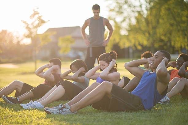 istock Doing Sit-Ups Outside in a Fitness Class 517051554