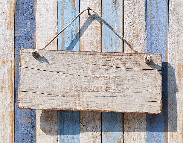 istock Old weathered white wood signboard hanging from an old nail. 517052464