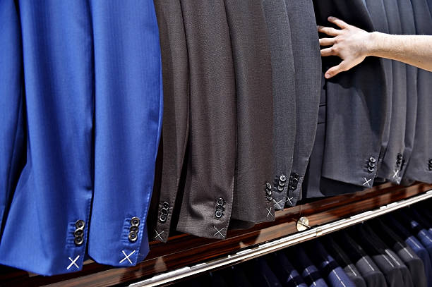 istock Man's hand pick out suit jacket in shop 517052748