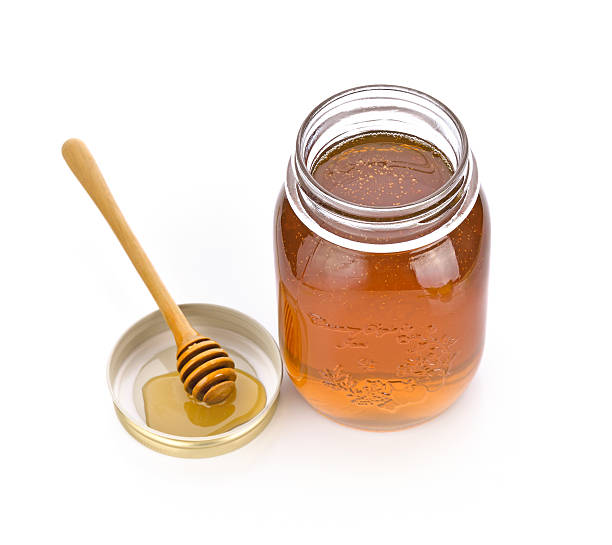 istock honey dipper and honey in jar on white background 517052796