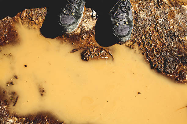 istock Hiking boots in front of a brown puddle. 517052904