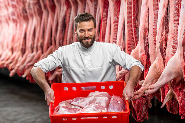 istock Butcher holding red box full with raw pork 517054102
