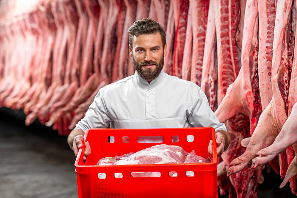 istock Butcher holding red box full with raw pork 517054182