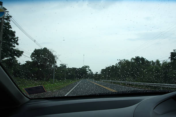 istock Road view through car window with rain drops. 517054297