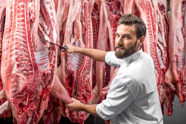 istock Butcher cutting pork at the manufacturing 517055110