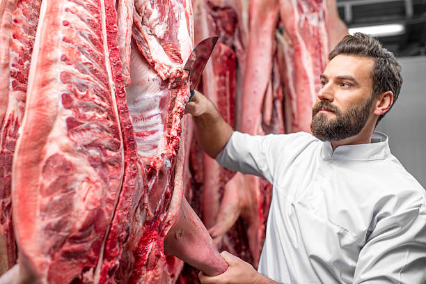 istock Butcher cutting pork at the manufacturing 517055444