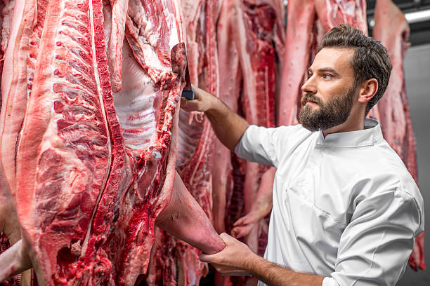 istock Butcher cutting pork at the manufacturing 517055556