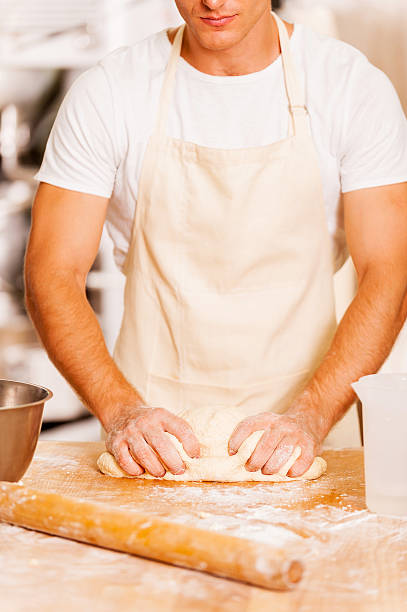 Baker kneading the dough.