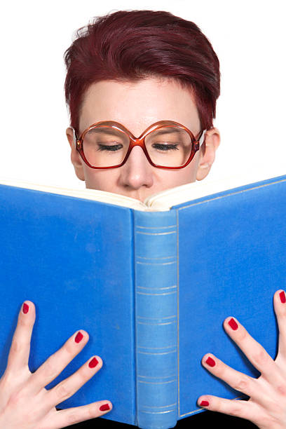 istock woman with glasses reading in a blue book 517055924