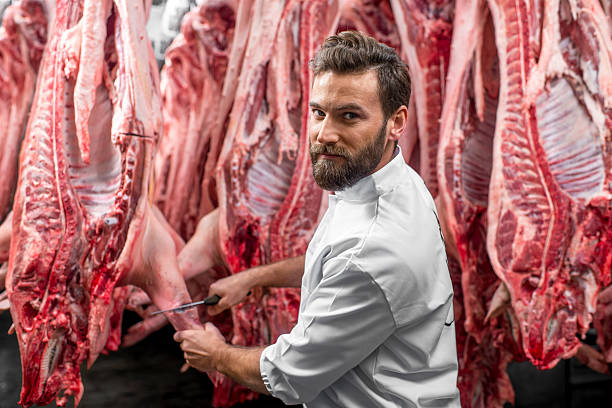 istock Butcher cutting pork at the manufacturing 517056146