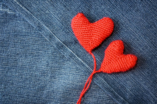 istock Knitted heart on blue jeans texture background 517056935